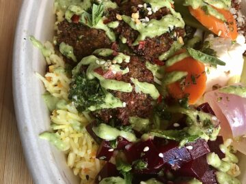 Rice bowl with falafel, green dressing, and vegetables